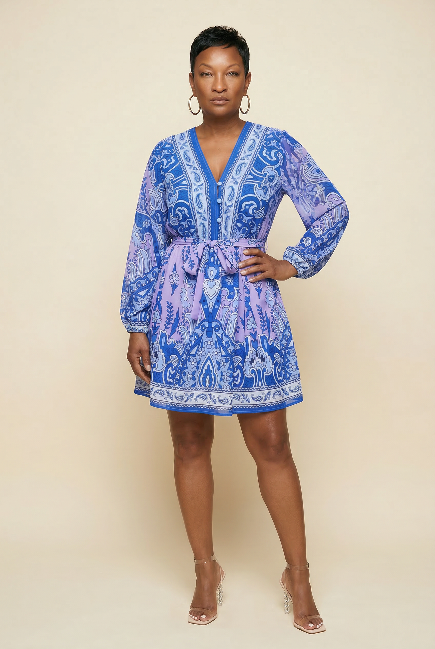 Woman wearing a blue patterned dress against a beige background