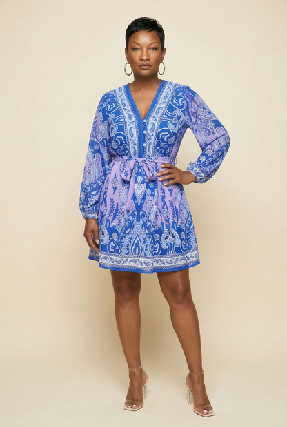 Woman wearing a blue patterned dress against a beige background