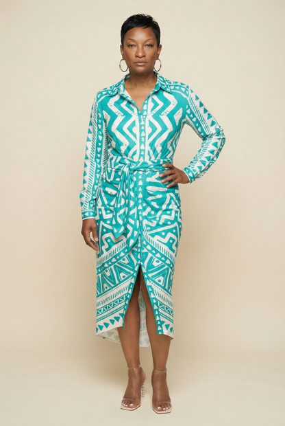 Woman wearing a teal patterned dress against a beige background
