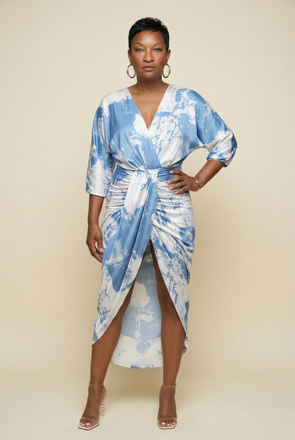 Woman wearing a blue and white patterned dress against a beige background