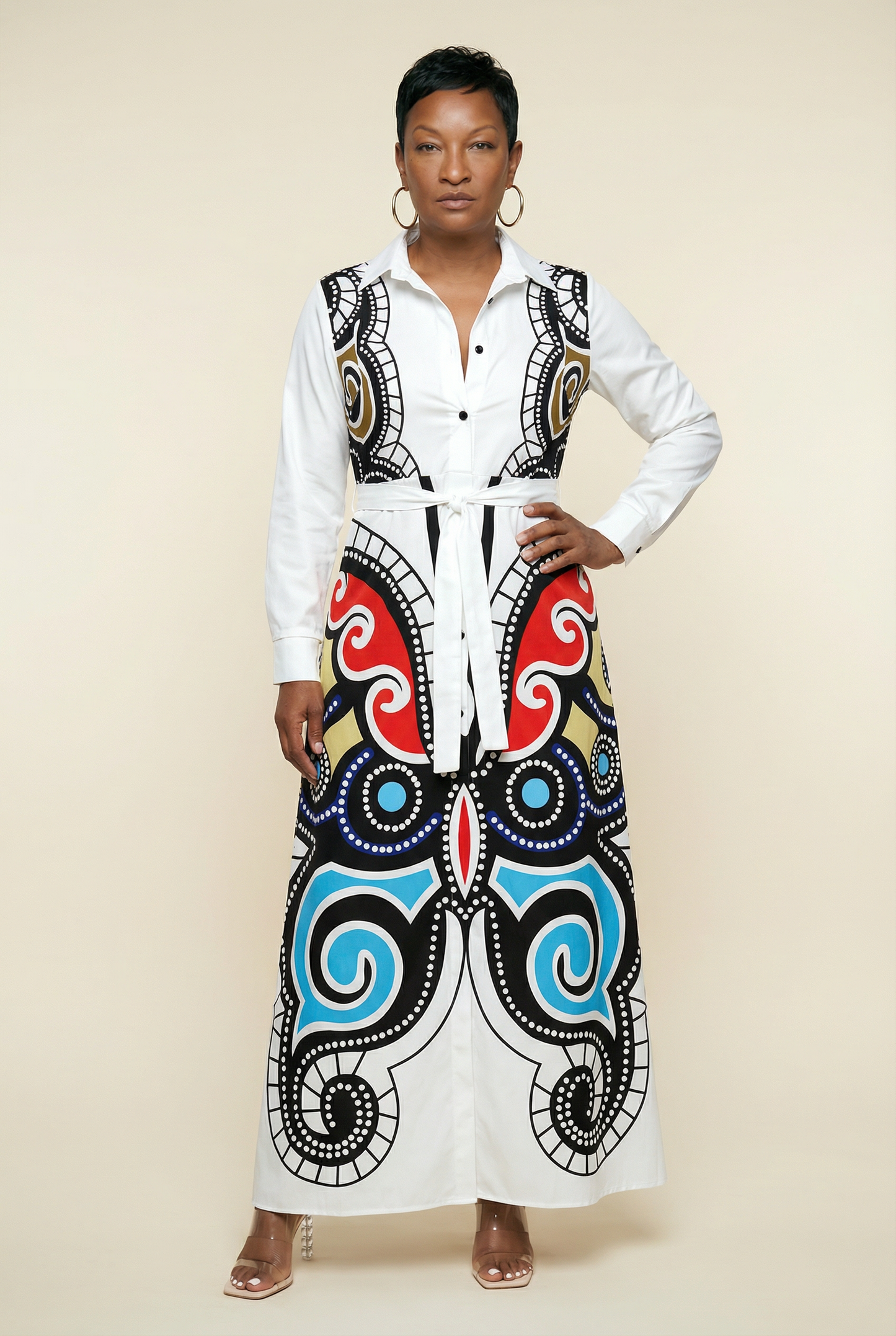Woman wearing a white blouse with a colorful, patterned skirt on a beige background