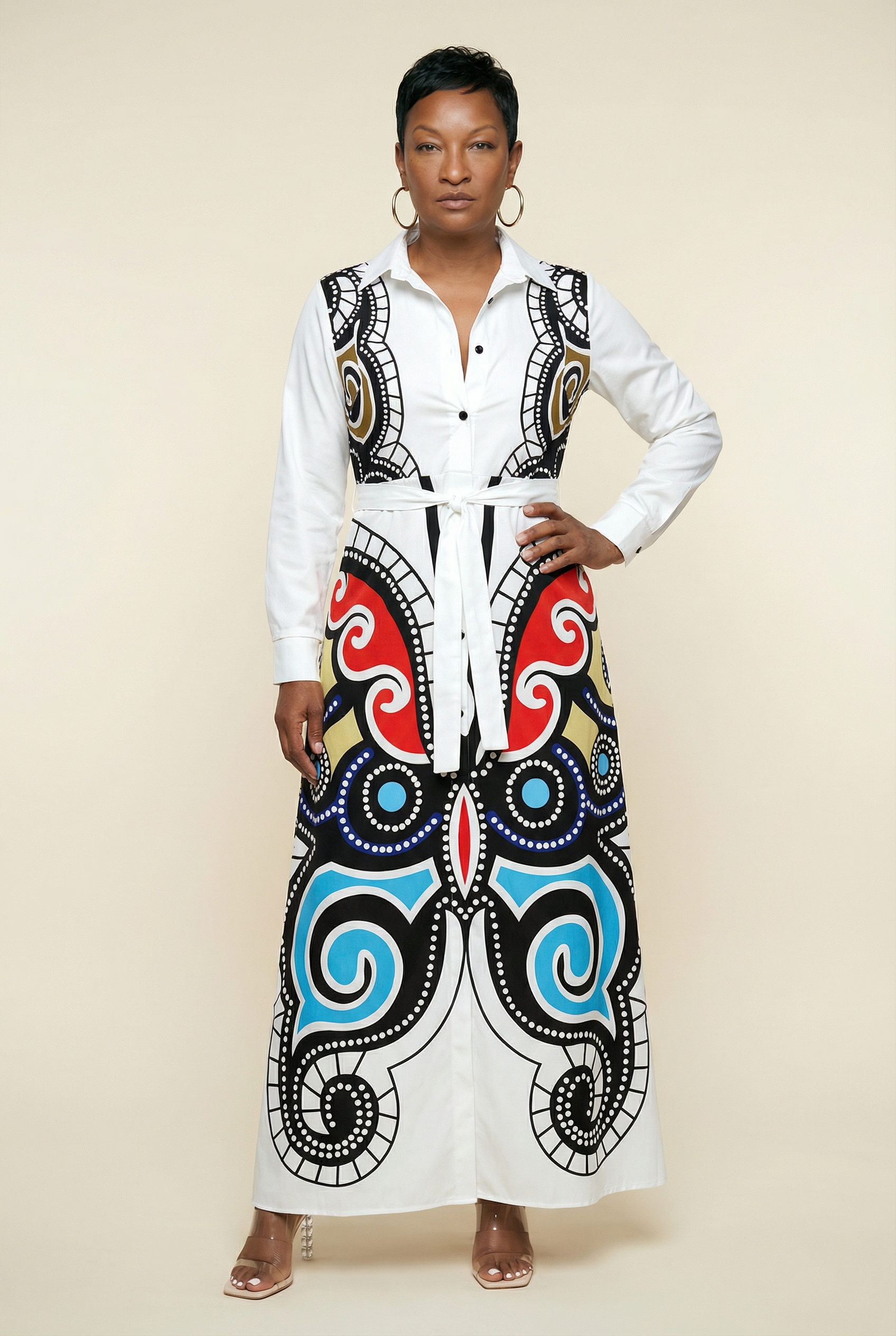 Woman wearing a white blouse with a colorful, patterned skirt on a beige background