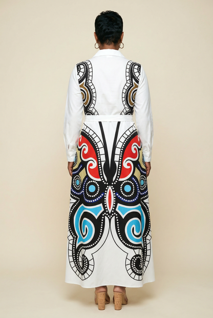 Person wearing a white outfit with a colorful butterfly pattern on a beige background