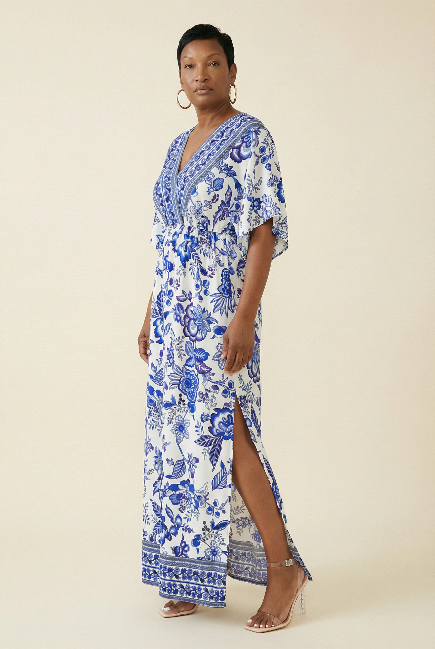 Woman wearing a blue and white floral dress on a beige background
