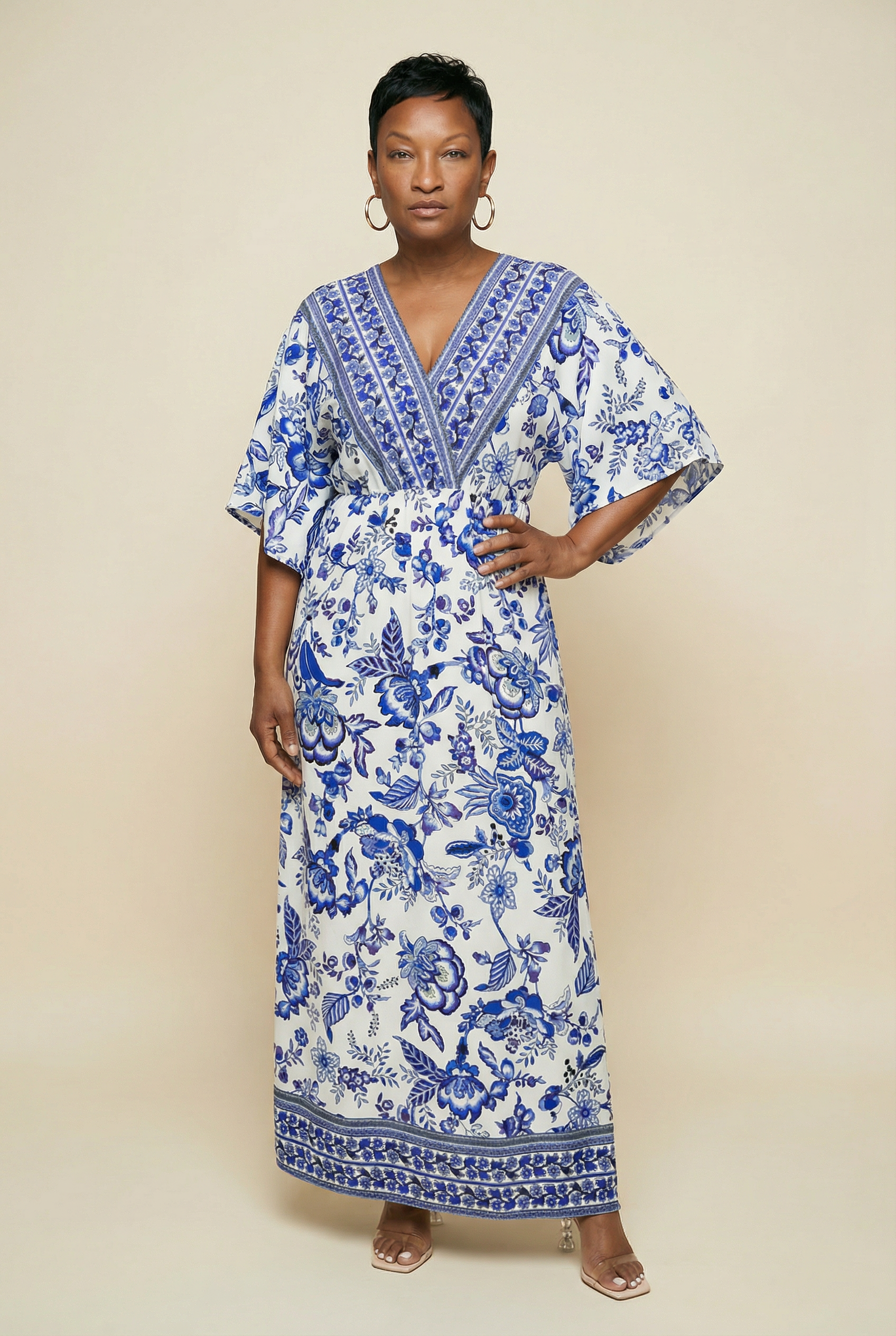 Woman wearing a blue and white floral dress against a beige background