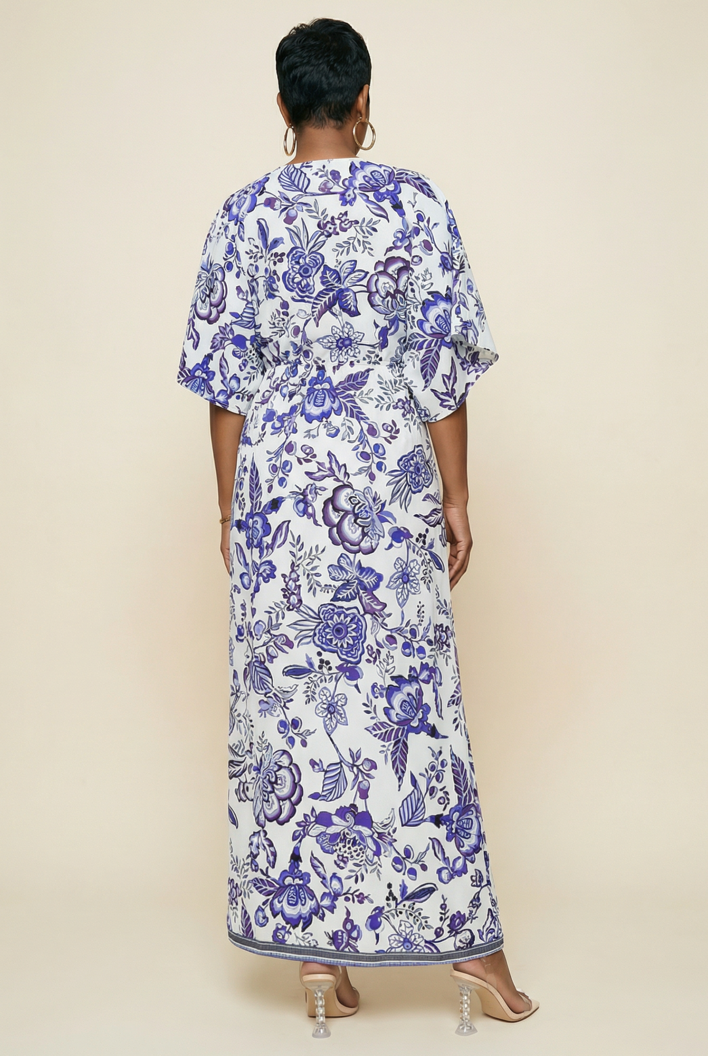 Woman wearing a long floral dress with a white background
