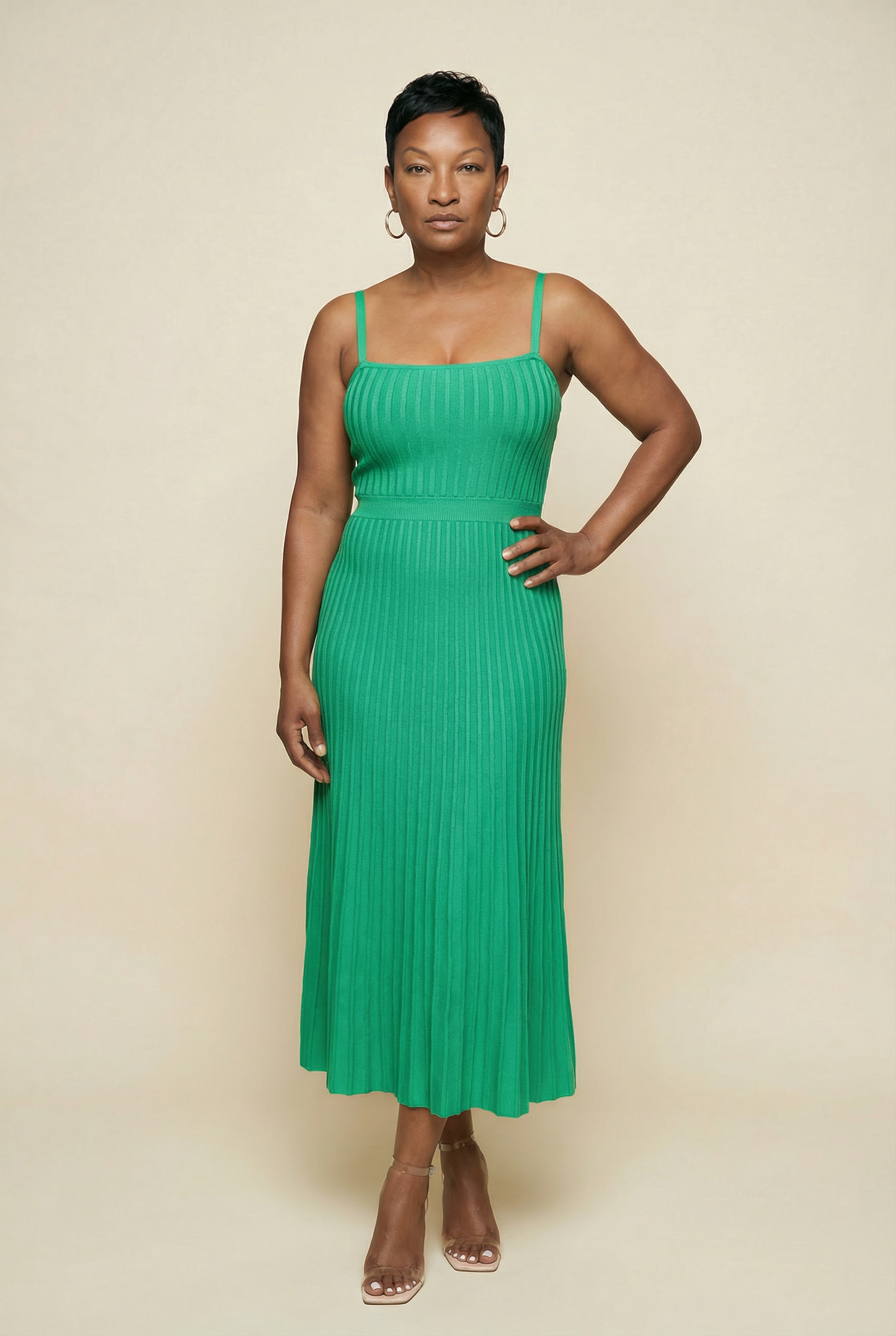 Woman wearing a green dress against a beige background