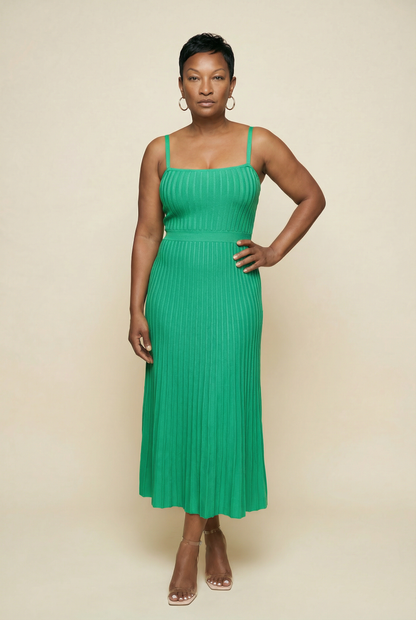 Woman wearing a green dress against a beige background