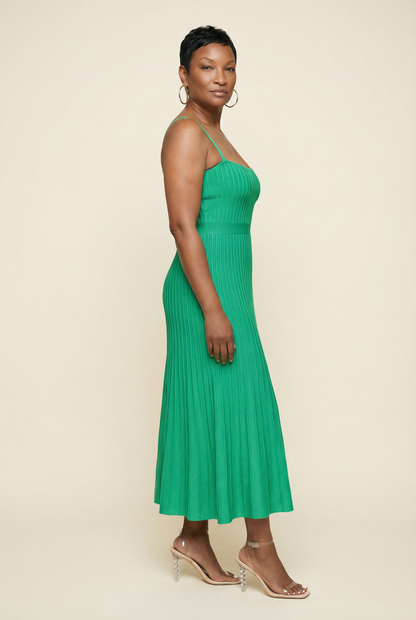 Woman wearing a green dress against a beige background