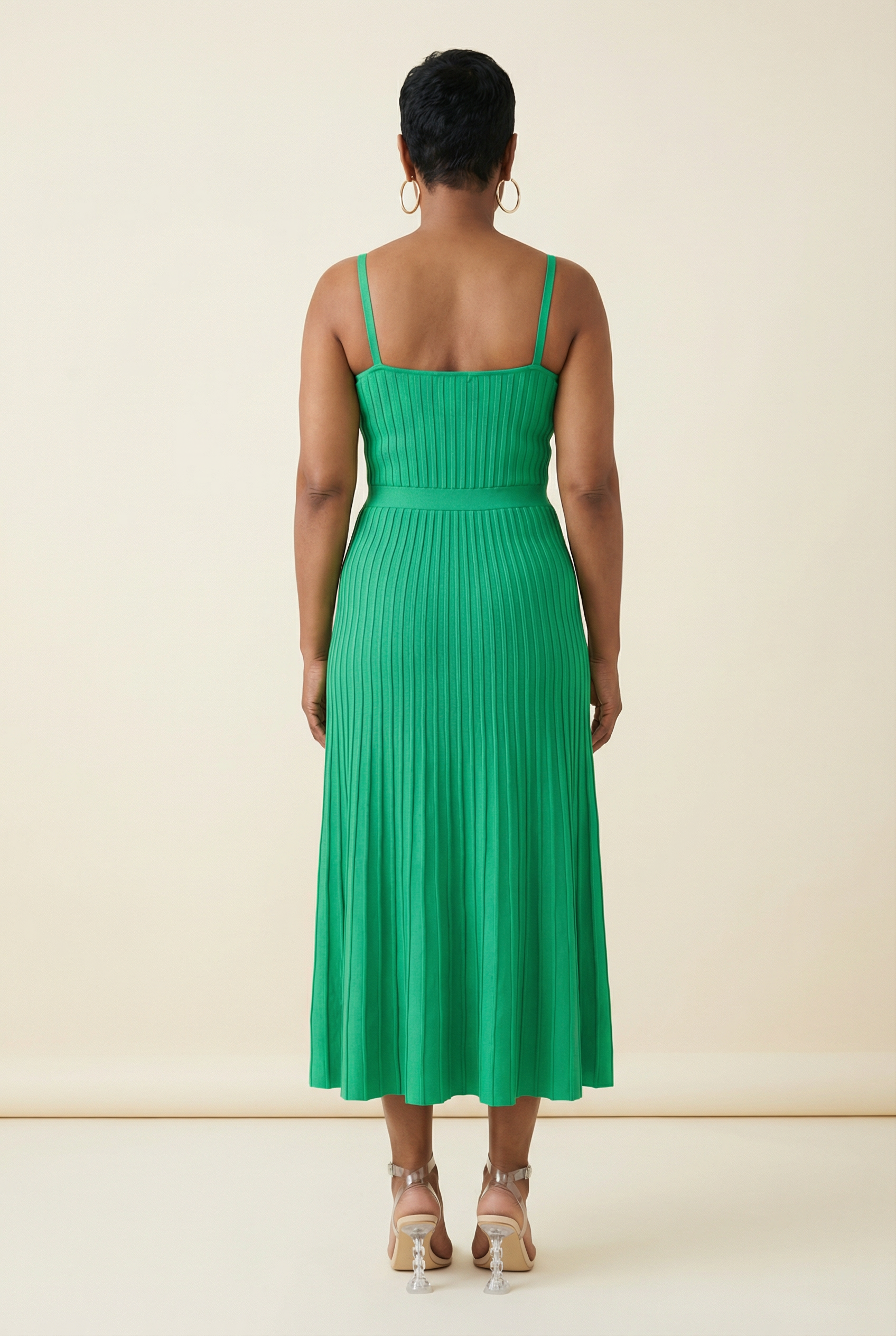 Woman wearing a green dress against a beige background